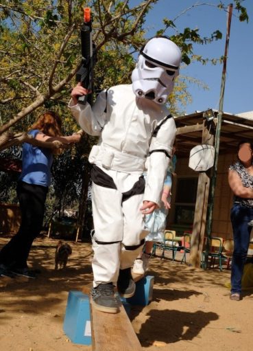 ילד מחופש לחייל ממלחמת הכוכבים חוצה את קורת העץ של בלונים ושוקולד ביום הולדת קלאש רויאל